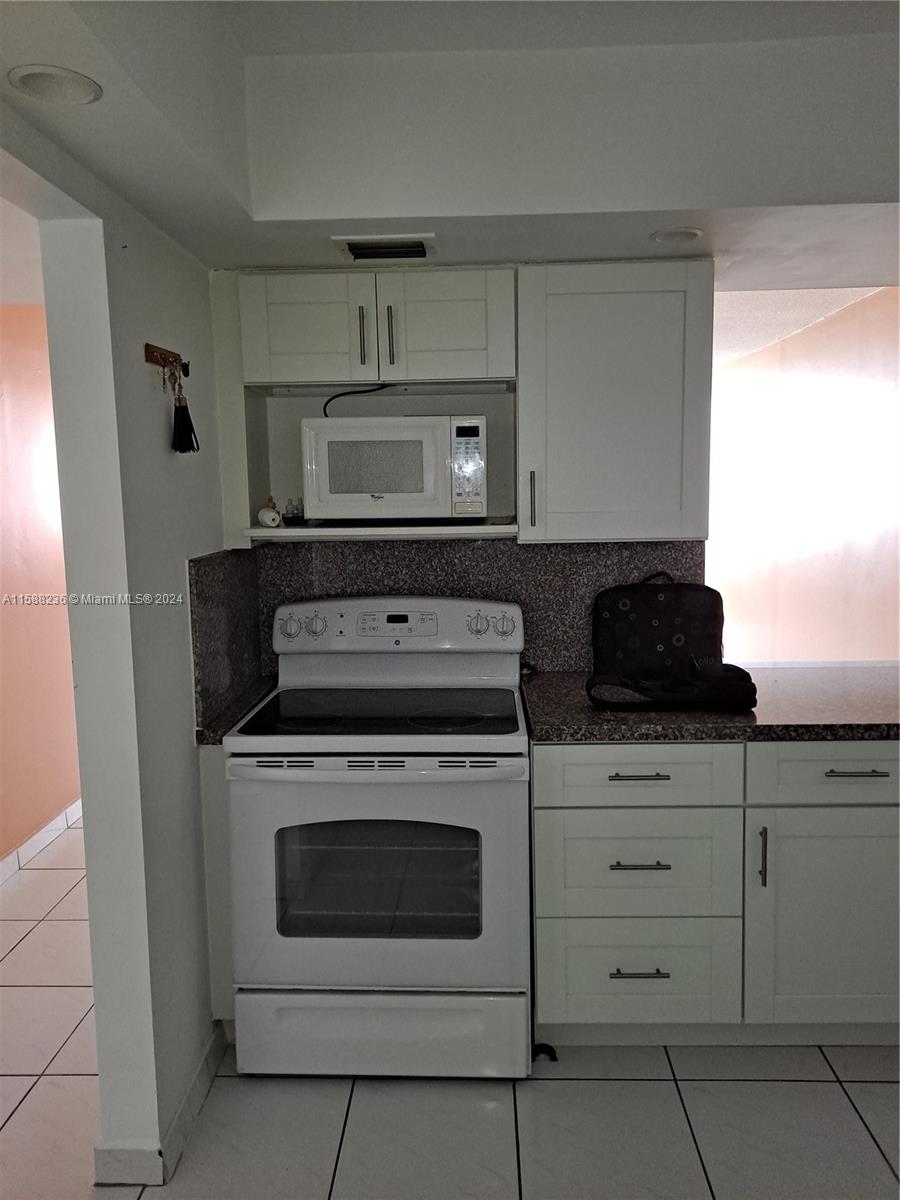 Buckley Towers Miami, FL 33179 - Photo 3 of 10 a kitchen with white cabinets and appliances