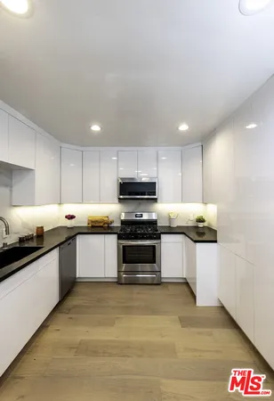 a large kitchen with stainless steel appliances granite countertop a stove and a sink