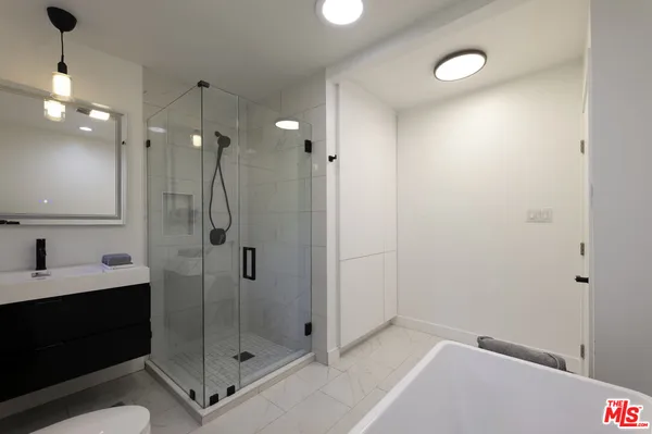 a bathroom with a shower sink vanity and mirror