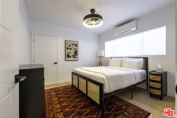 a bedroom with a bed and a painting on the wall