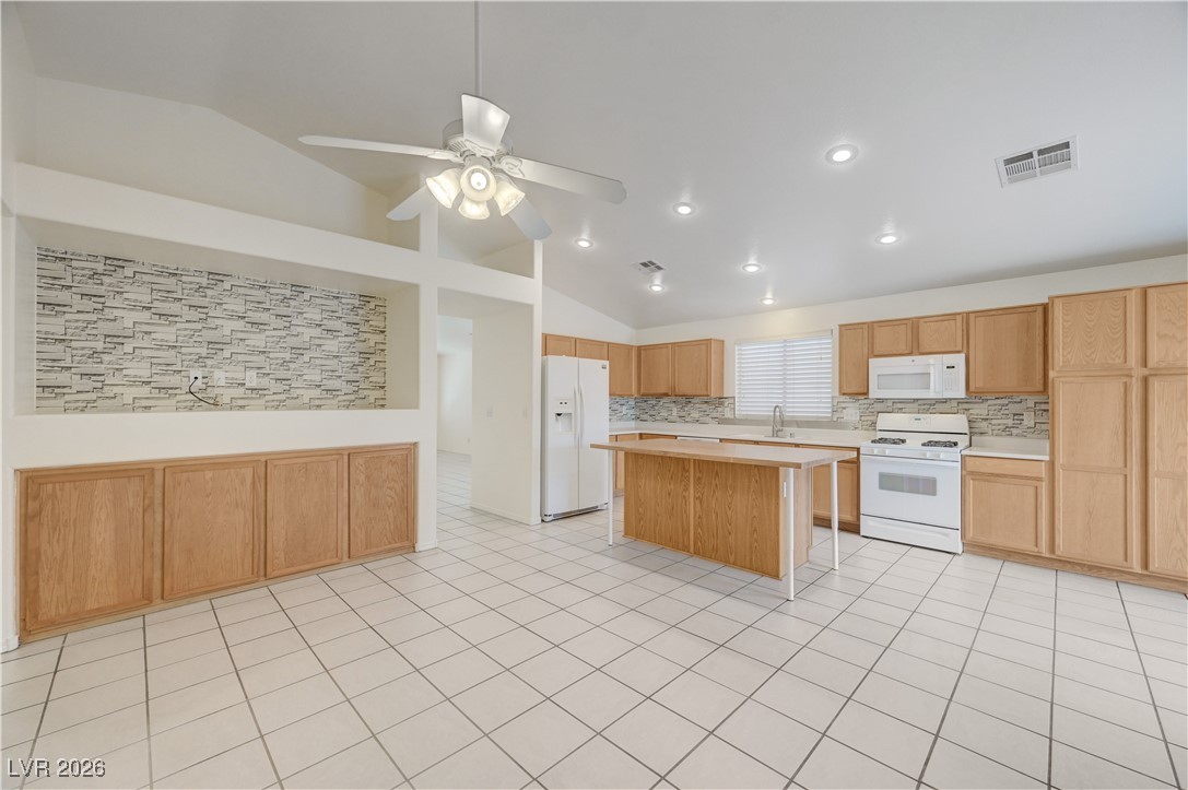9929 Princess Cut Street Las Vegas, NV 89183 - Photo 14 of 52 Kitchen featuring lofted ceiling, light countertops, white appliances, a center island, and ceiling fan