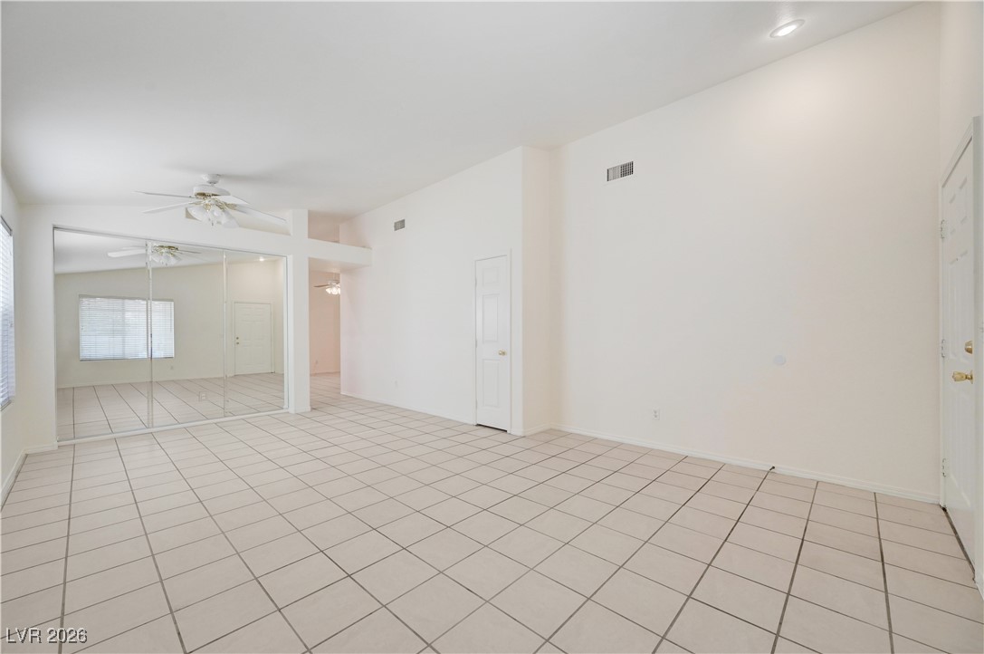 9929 Princess Cut Street Las Vegas, NV 89183 - Photo 9 of 52 Unfurnished room featuring a ceiling fan, lofted ceiling, and light tile patterned flooring