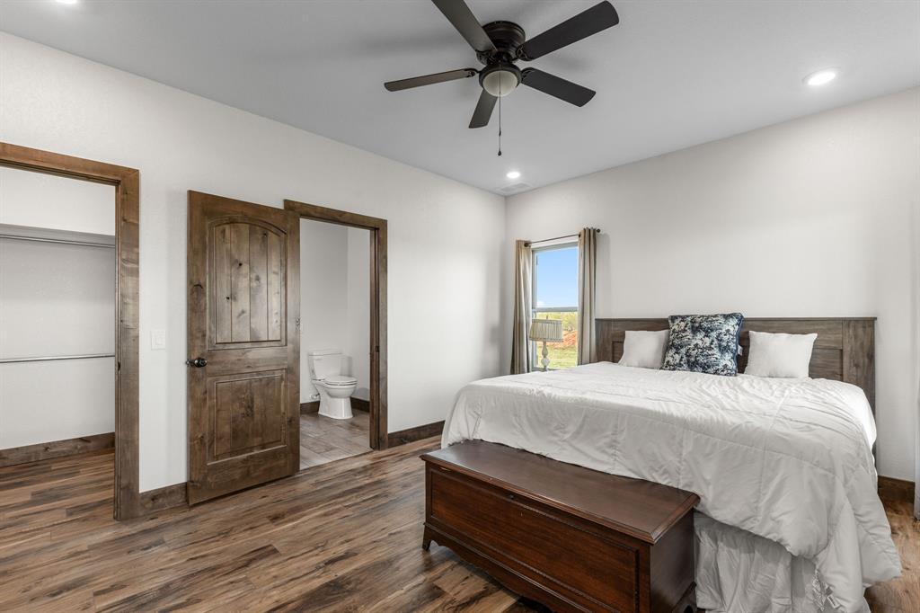 515 Sales Road Windthorst, TX 76389 - Photo 23 of 34 a bedroom with a bed and wooden floor