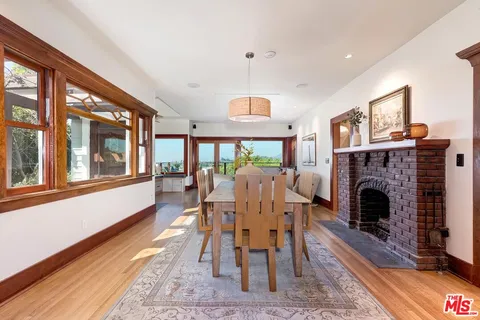 a kitchen with granite countertop a dining table chairs refrigerator and wooden floor