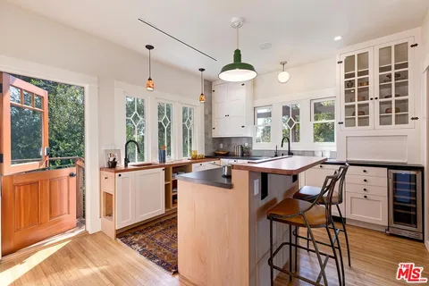 a large kitchen with stainless steel appliances a sink a stove and a window