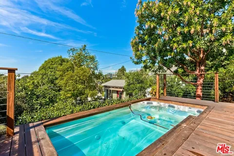 a roof deck with table and chairs and potted plants