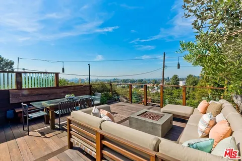 a view of a chairs and table on the roof deck