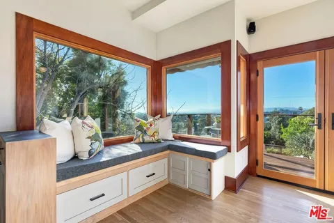 a living room with furniture kitchen view and a large window