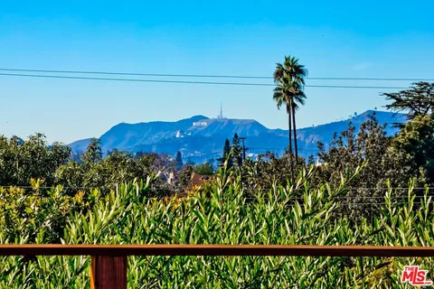 a living room with furniture a large window and dining table