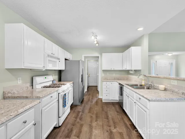 a kitchen with a white stove top oven sink and cabinets