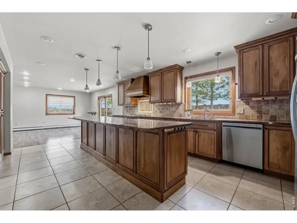 a kitchen with kitchen island granite countertop a stove sink and microwave