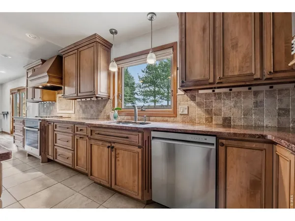 a kitchen with stainless steel appliances granite countertop a sink a stove cabinets and wooden floor