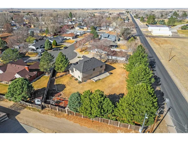 an aerial view of residential houses with outdoor space and trees