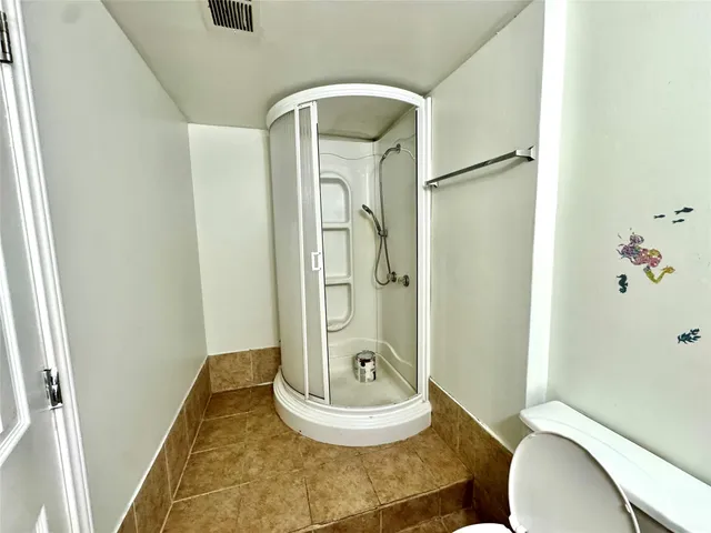 a bathroom with a granite countertop sink toilet mirror vanity and bathtub