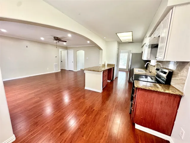 a view of hallway with wooden floor and cabinet