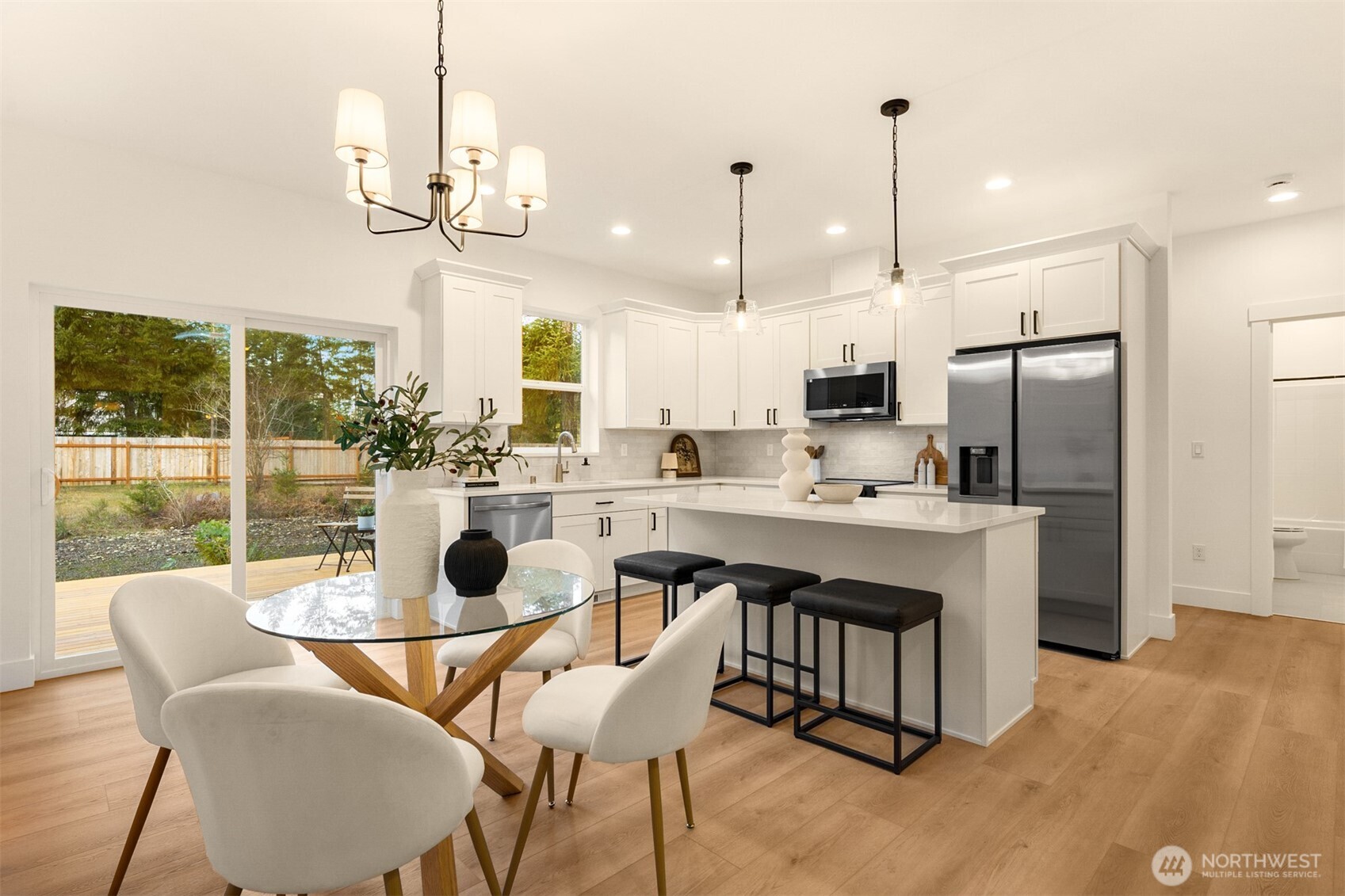 3000 West Martin Road Shelton, WA 98584 - Photo 13 of 38 a kitchen with stainless steel appliances kitchen island granite countertop a table chairs and a chandelier