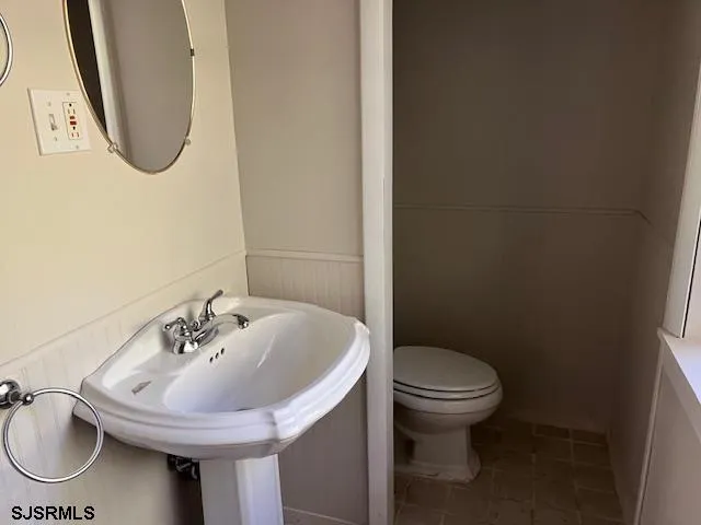 a bathroom with a sink a toilet and a mirror