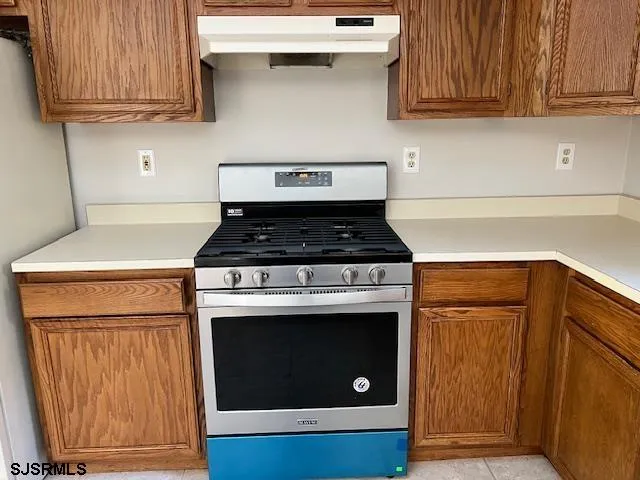 a kitchen with granite countertop wood cabinets and stainless steel appliances