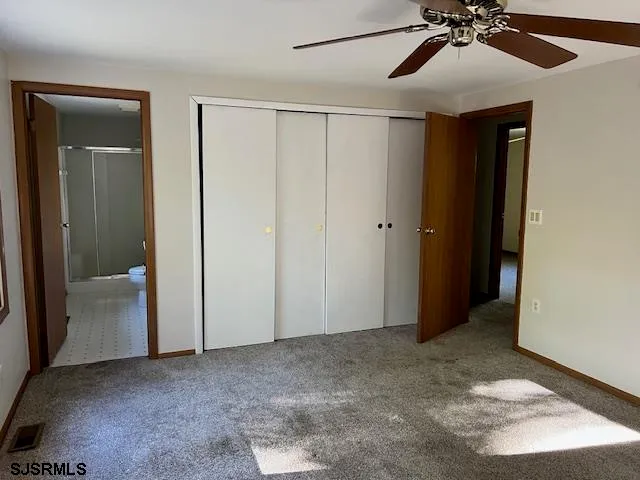 a view of an empty room with a ceiling fan