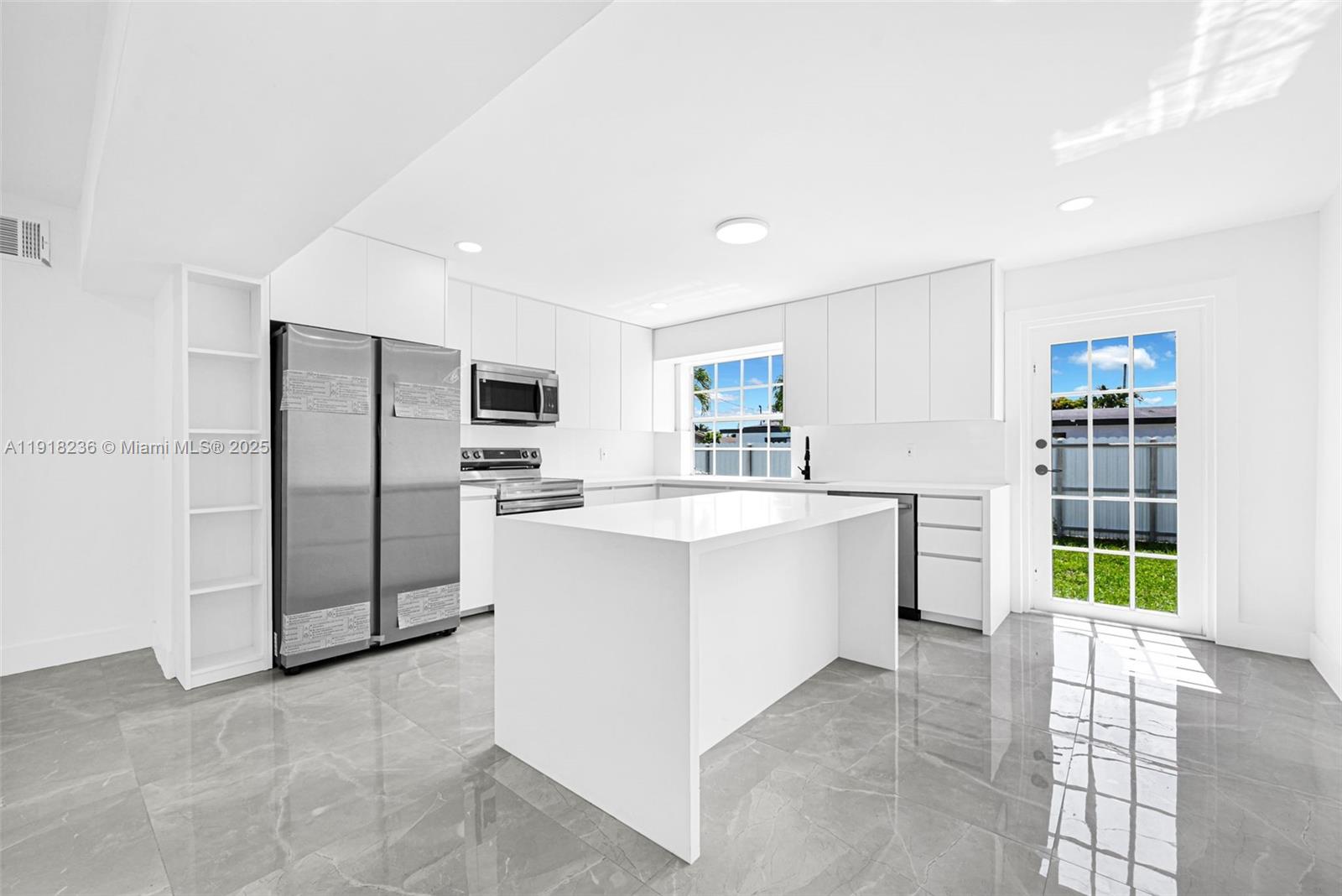 a large white kitchen with cabinets and stainless steel appliances