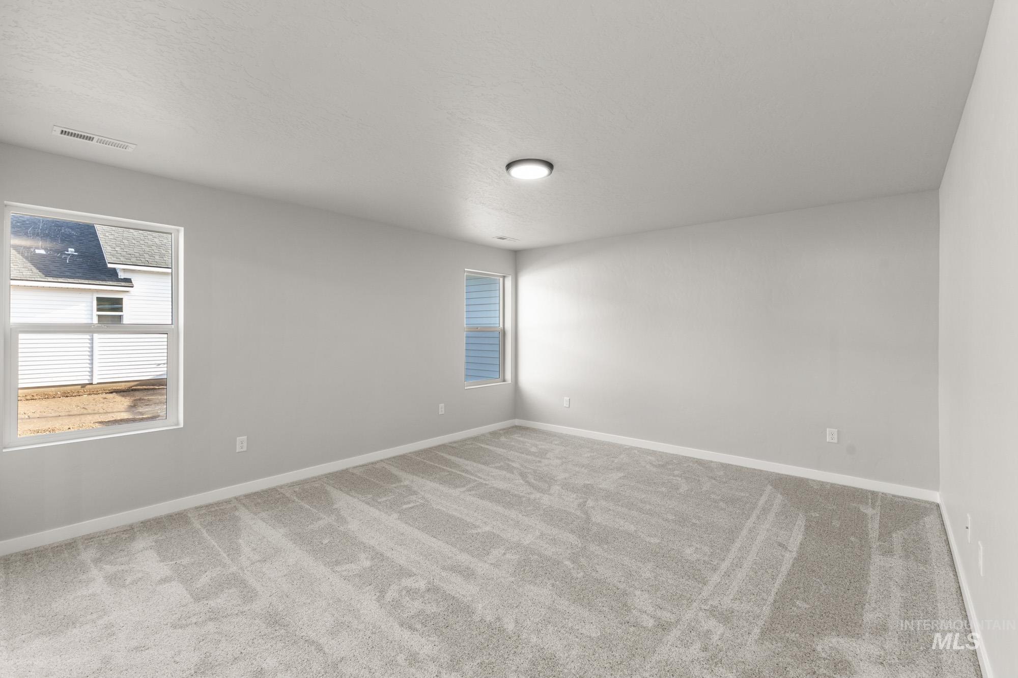 436 Merlin Court Middleton, ID 83644 - Photo 17 of 20 Spacious room featuring light-colored walls, patterned carpet flooring, and white trim