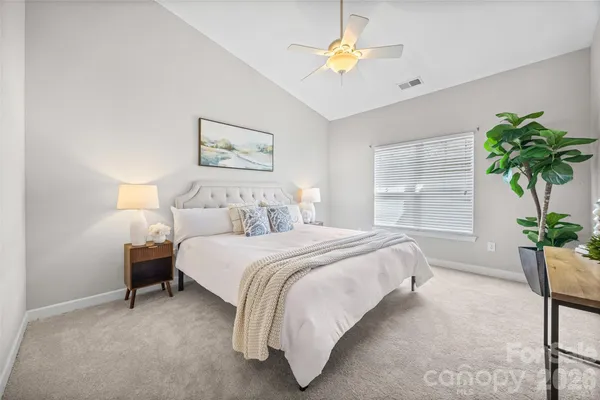 a bedroom with a bed and a potted plant