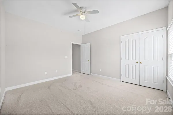 an empty room with a ceiling fan and a window