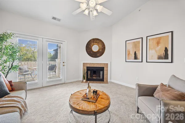 a living room with furniture a fireplace and a large window