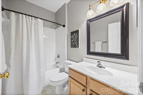 a bathroom with a granite countertop sink toilet and mirror