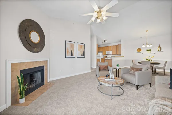 a living room with furniture a fireplace and a chandelier