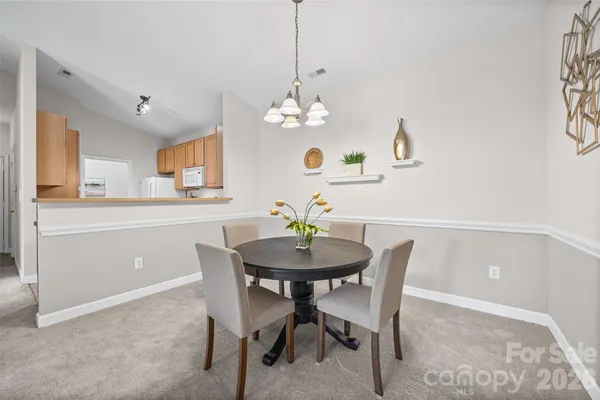 a view of a dining room with furniture and a chandelier