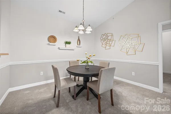 a view of a dining room with furniture and a chandelier