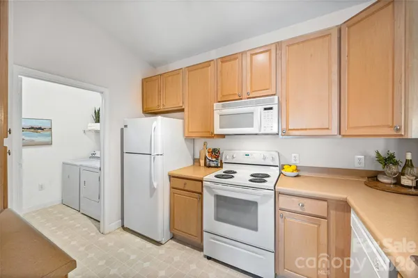 a kitchen with white cabinets and white appliances