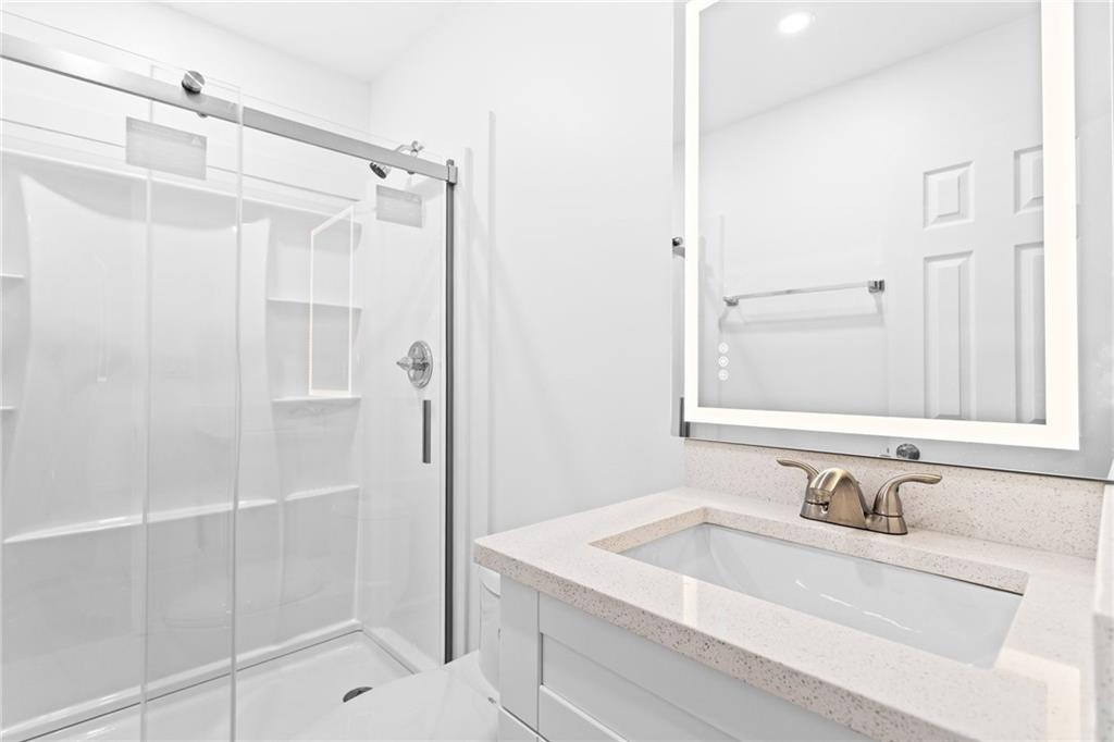 2304 South Hairston Road Decatur, GA 30035 - Photo 12 of 23 a bathroom with a granite countertop sink mirror and shower