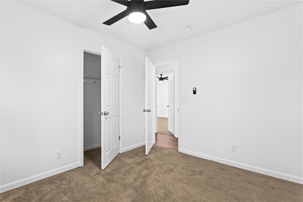 2304 South Hairston Road Decatur, GA 30035 - Photo 13 of 23 an empty room with a ceiling fan and carpet