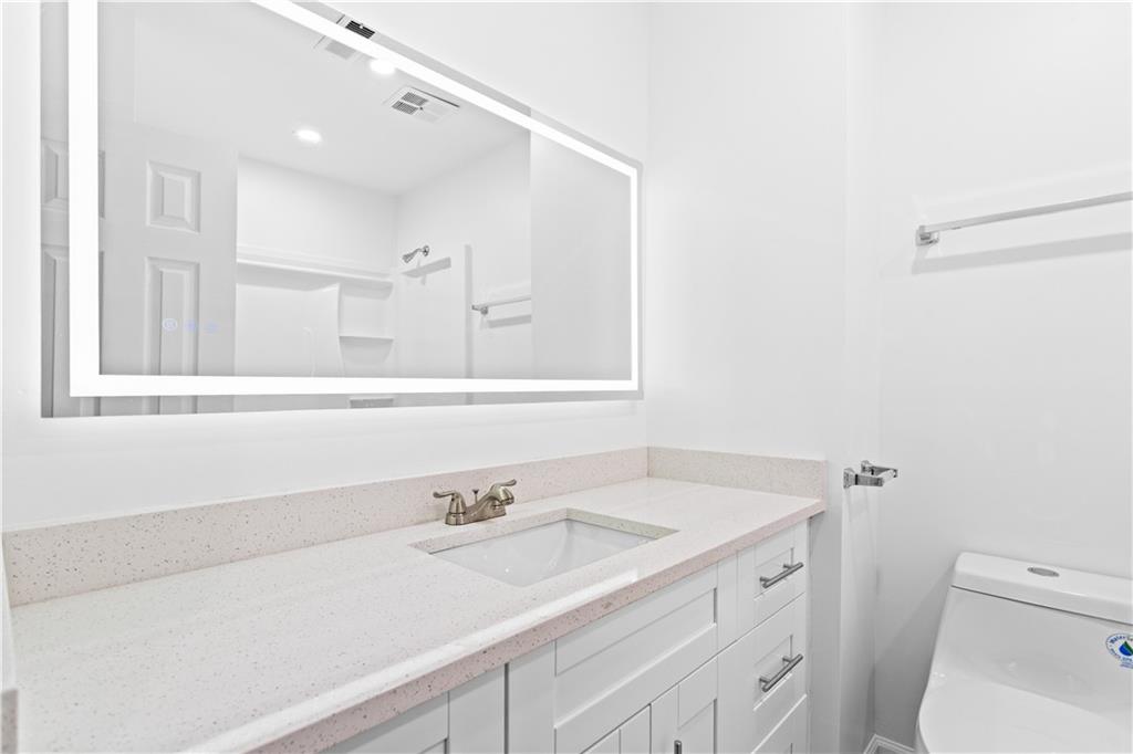 2304 South Hairston Road Decatur, GA 30035 - Photo 15 of 23 a bathroom with a sink a toilet and a mirror