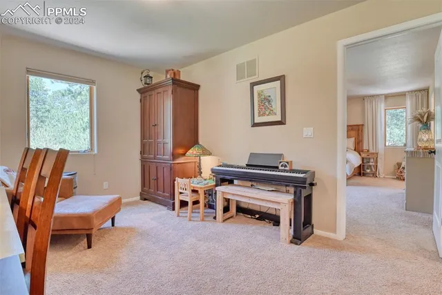 a living room with furniture a piano and a window