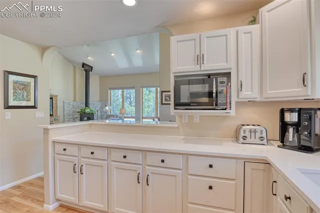 a kitchen with white cabinets and stainless steel appliances