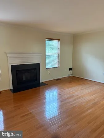 a view of empty room with wooden floor and fireplace