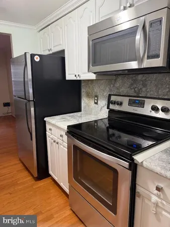 a kitchen with granite countertop a stove microwave and refrigerator
