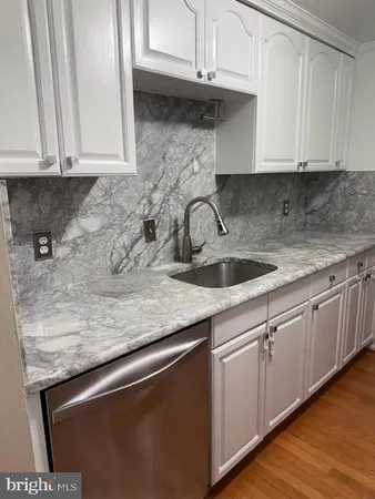 a kitchen with granite countertop a sink a stove and cabinets