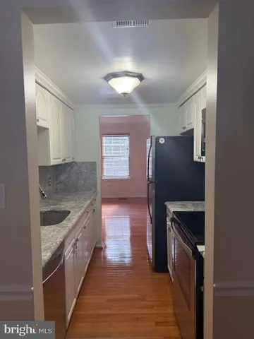 a kitchen with granite countertop a refrigerator and a sink