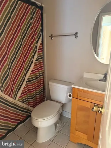 a white toilet sitting next to a shower curtain
