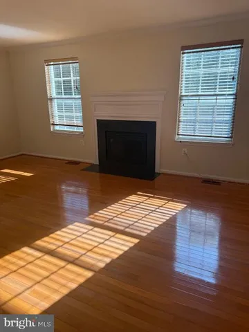 a view of empty room with wooden floor and fireplace
