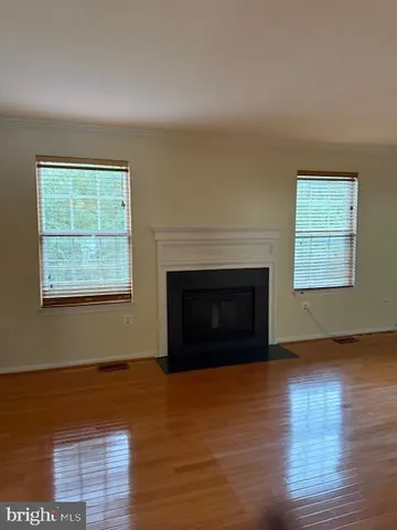 an empty room with windows and a fireplace