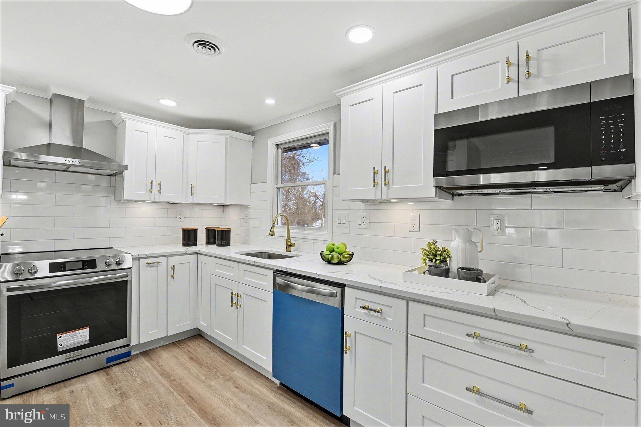 1009 Maple Road Essex, MD 21221 - Photo 4 of 26 a kitchen with stainless steel appliances granite countertop a sink a stove top oven a counter space and cabinets