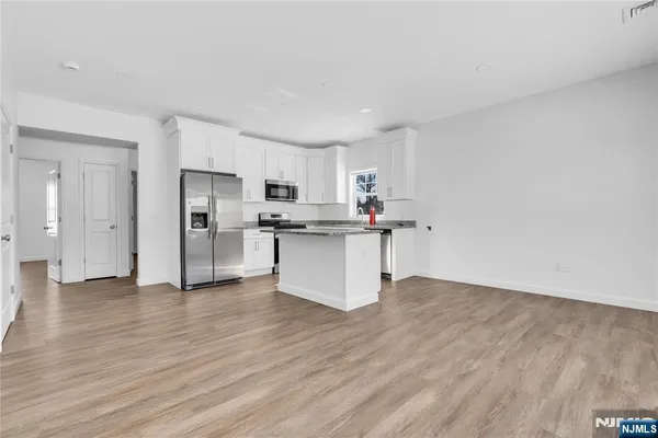 a kitchen with stainless steel appliances a refrigerator and a stove top oven
