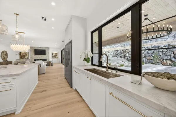 a living room with furniture a table and kitchen view