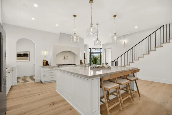 a large white kitchen with a large window and stainless steel appliances