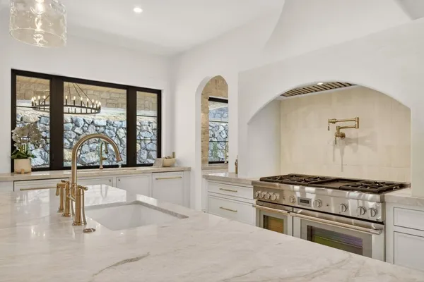 a kitchen with a stove a sink and a cabinets